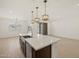 Open kitchen with stainless steel appliances, dark wood cabinets, and island with quartz countertops at 16072 W Prickly Pear Trl, Surprise, AZ 85387