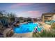 Sparkling pool with rock waterfall feature and outdoor lounge area, perfect for relaxing and entertaining at 17939 W Lavender Ln, Goodyear, AZ 85338