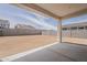 Empty backyard framed by a covered patio, block walls, and with a view of houses under construction at 3247 W Garnet St, San Tan Valley, AZ 85144
