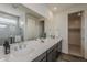 Bathroom showcasing double sinks, a large mirror, and a walk-in shower, with modern fixtures and finishes at 3247 W Garnet St, San Tan Valley, AZ 85144