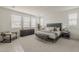 Bright bedroom featuring a modern bed frame, plush seating, and natural light from multiple windows at 3247 W Garnet St, San Tan Valley, AZ 85144