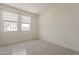 Empty bedroom with neutral walls and carpet, featuring windows that let in lots of light at 3247 W Garnet St, San Tan Valley, AZ 85144