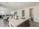 Open-concept kitchen island with stainless steel sink, quartz countertop, and seating for four at 3247 W Garnet St, San Tan Valley, AZ 85144