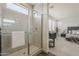Bright bathroom with a modern tiled shower, glass door, and view into the bedroom area at 3247 W Garnet St, San Tan Valley, AZ 85144