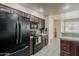 Well-equipped kitchen with modern appliances and dark wood cabinetry with tiled floors at 4202 E Broadway Rd # 132, Mesa, AZ 85206