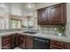 Stylish kitchen featuring dark wood cabinets, tile countertops, and a black dishwasher at 4202 E Broadway Rd # 132, Mesa, AZ 85206