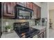 Updated kitchen features sleek black appliances and dark wood cabinetry at 4202 E Broadway Rd # 132, Mesa, AZ 85206