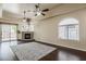 Spacious living room with fireplace, hardwood floors, ceiling fans, and a sliding glass door to patio at 4202 E Broadway Rd # 132, Mesa, AZ 85206