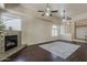 Bright living room with fireplace, hardwood floors, ceiling fans, and an open doorway to the kitchen at 4202 E Broadway Rd # 132, Mesa, AZ 85206