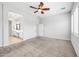 Bright bedroom featuring carpet, ceiling fan, and access to the ensuite bathroom at 10605 E Monterey Ave, Mesa, AZ 85209