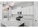 Modern kitchen featuring white cabinets, granite countertops, and stainless steel appliances at 10605 E Monterey Ave, Mesa, AZ 85209