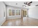 Bright living room featuring tile floors, plantation shutters, and a ceiling fan at 10605 E Monterey Ave, Mesa, AZ 85209