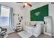 Bright bedroom with a daybed, green wall, and mirror at 14953 W Cortez St, Surprise, AZ 85379