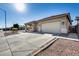 Tan house with a two-car garage and desert landscaping at 14953 W Cortez St, Surprise, AZ 85379