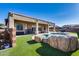 Inviting backyard oasis with a rock-structured pool and patio at 14953 W Cortez St, Surprise, AZ 85379