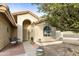 Inviting front entry with a brick walkway and small patio seating area at 24404 S Boxwood Dr, Sun Lakes, AZ 85248