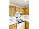 View of kitchen stove, microwave, and wood cabinets at 24404 S Boxwood Dr, Sun Lakes, AZ 85248