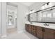 Elegant bathroom featuring dual sinks, wood cabinetry, and modern fixtures at 32962 N 131St Dr, Peoria, AZ 85383