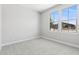 Well-lit bedroom featuring neutral carpeting and a view of the neighborhood at 32962 N 131St Dr, Peoria, AZ 85383