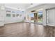Spacious living room featuring hardwood floors, sliding doors and multiple windows that fill the room with natural light at 32962 N 131St Dr, Peoria, AZ 85383