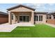Backyard showcasing desert landscaping, a patio, synthetic grass, and neutral colors at 32994 N 131St Dr, Peoria, AZ 85383