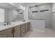 Elegant bathroom with double vanity, a walk-in shower with tile surround and sleek fixtures at 32994 N 131St Dr, Peoria, AZ 85383
