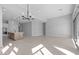 Open-concept living space with a kitchen island, modern lighting, and tile flooring at 32994 N 131St Dr, Peoria, AZ 85383