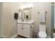 Well-lit half bathroom features modern vanity, mirror, and fixtures with neutral colors and a tile accent wall at 3650 N Barron --, Mesa, AZ 85207