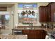 A close up view of a kitchen sink with stainless appliances, granite countertops, and natural light at 3650 N Barron --, Mesa, AZ 85207