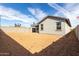 View of the home's backyard showing dirt and a covered patio area at 8584 N 170Th Ln, Waddell, AZ 85355