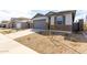 Beautiful single-Gathering home featuring stone accents, a gray garage door, and desert landscaping at 8584 N 170Th Ln, Waddell, AZ 85355