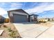 Attractive single-Gathering home featuring stone accents, a gray garage door, and drought-tolerant landscaping at 8584 N 170Th Ln, Waddell, AZ 85355