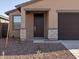 Dark brown front door with stone accents on a new home at 9109 N 173Rd Ln, Waddell, AZ 85355