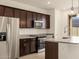 Spacious kitchen featuring stainless steel appliances and dark wood cabinets at 9109 N 173Rd Ln, Waddell, AZ 85355