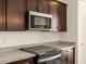 Modern kitchen with granite countertops and stainless steel microwave at 9109 N 173Rd Ln, Waddell, AZ 85355