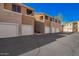 Apartment building featuring private garages, balconies, and well-maintained grounds with blue sky at 1335 E June St # 239, Mesa, AZ 85203