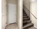 Hallway with carpeted stairs, white door, light tan walls, and tile floor at 1335 E June St # 239, Mesa, AZ 85203