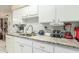 Kitchen with granite countertops, white cabinets, and various appliances at 13428 N Hawthorn Dr, Sun City, AZ 85351