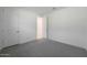 Cozy bedroom with gray carpet, white walls, and a doorway leading to another room at 14830 W El Cortez Pl, Surprise, AZ 85387