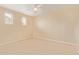 Carpeted bedroom with a ceiling fan and dual windows for natural light at 2121 W Tallgrass Trl # 126, Phoenix, AZ 85085