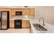 Modern kitchen featuring black appliances, light wood cabinets, and solid countertops for a clean and updated feel at 2121 W Tallgrass Trl # 126, Phoenix, AZ 85085