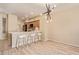 Stylish kitchen open to the living area, featuring modern lighting, a breakfast bar, and light wood cabinetry at 2121 W Tallgrass Trl # 126, Phoenix, AZ 85085