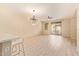Open-concept living room with light wood floors, modern chandelier, and sliding glass doors to bring in natural light at 2121 W Tallgrass Trl # 126, Phoenix, AZ 85085