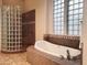 Luxurious bathroom featuring a soaking tub with tile surround and a glass block shower at 3701 E Sat Nam Way, Cave Creek, AZ 85331