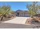 Beautiful, desert-landscaped home with a spacious driveway and a two-car garage, nestled under a clear blue sky at 3701 E Sat Nam Way, Cave Creek, AZ 85331