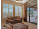 Comfortable sitting room featuring large windows with shutters and a sliding glass door to the patio at 3701 E Sat Nam Way, Cave Creek, AZ 85331