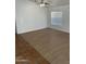 Bright living room with tile and wood-look floors, ceiling fan and large window at 7504 W Jenan Dr, Peoria, AZ 85345