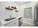 Modern kitchen sink and white subway tile backsplash with open shelving and stainless fixtures at 9600 N 96Th St # 130, Scottsdale, AZ 85258