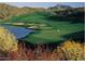 Picturesque golf course view with water feature, sand traps, and mountain backdrop surrounded by colorful wildflowers at 14645 N Fountain Hills Blvd # 114, Fountain Hills, AZ 85268