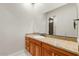 Bathroom with granite countertops, wood cabinets, and a large mirror at 2121 N Orchard --, Mesa, AZ 85213